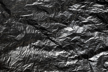 Old black plastic bag crumpled to make pattern and shadow. For use as background.