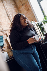 Positive woman laughing in her kitchen stock photo