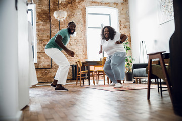 Excited dancing couple at home stock photo