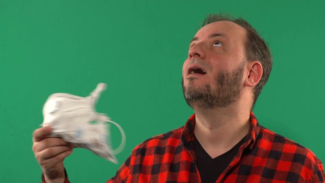 Close Up Of a Man With A Medical Mask Filmed On Chroma Key. Man Wearing Hygienic Mask. Coronavirus Protection Covid - 19. Portrait Of Medical Doctor Putting Mask On Green Background. 4K video