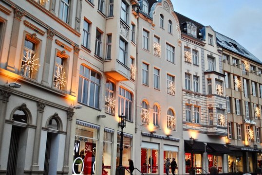 Row of white European storefronts on Martinsplatz Street decorated for Christmas sales with holiday shoppers. 