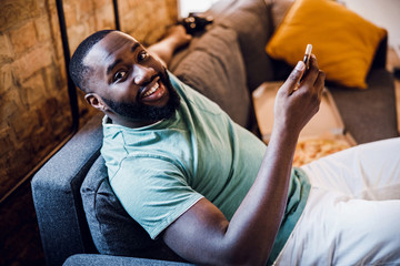 Positive Afro American man with gadget in his hand stock photo