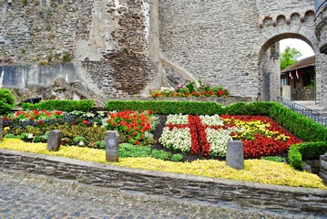 COCHEM, GERMANY - 2014: Flowers planted to represent the seal of Cochem. Exterior of the Cochem Castle (Reichsburg or Burg Cochem), which is a castle in the Rhineland-Palatinate on the Moselle.