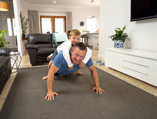 COVID-19 Outrbreak. Father and son exercising together at home during coronavirus quarantine