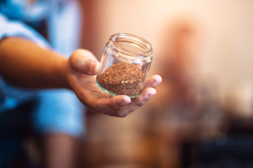 Barista show coffee beans in drip glass.