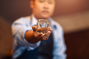 Barista show coffee beans in drip glass.