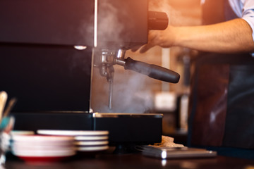 Barista making fresh coffee with coffee machine in cafe