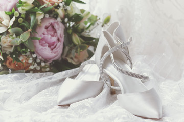 Obraz na płótnie Canvas Bride's white wedding shoes and wedding flowers