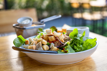 salad with tuna, salad dressing in bowl on the table.
