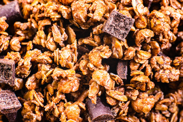 Detail of a bowl with warm shades of oatmeal and chocolate granola.