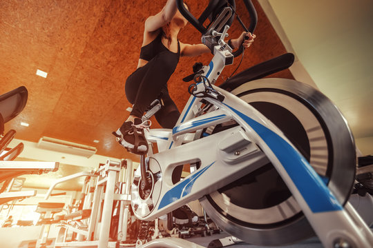 Exercise bike cardio workout at fitness gym. women doing sport biking in the gym for fitness.