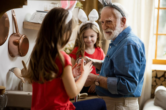 Happy grandpa cooking and talking to girl stock photo