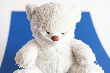 teddy bear in medical mask on a classic blue background