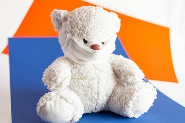 teddy bear in medical mask on a classic blue and lush lava background color