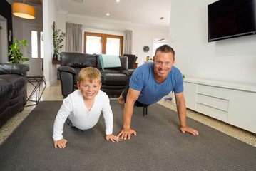 COVID-19 Outrbreak. Father and son exercising together at home during coronavirus quarantine