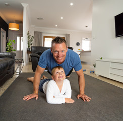 COVID-19 Outrbreak. Father and son exercising together at home during coronavirus quarantine