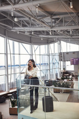 Fototapeta premium Pretty lady talking on mobile phone in departure lounge