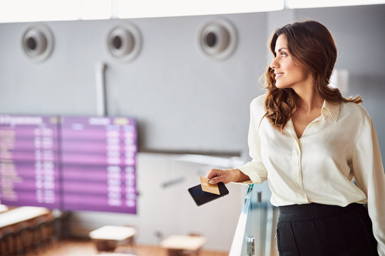 Beautiful young woman holding smartphone and gold card