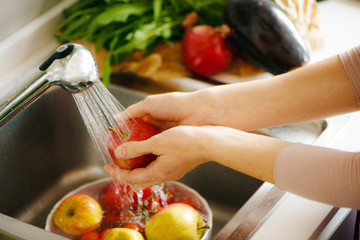 Washing fruit in the kitchen, white hands © Alextype