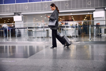 Beautiful businesswoman with luggage walking in airport