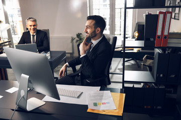 Smiling bearded guy talking to his employee indoors