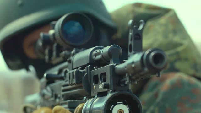 A soldier fires from a machine gun