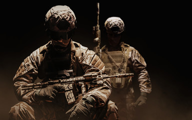 Soldiers in uniform sitting and standing  with rifle