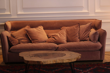 A brown sofa and a trendy coffee table in front of it.