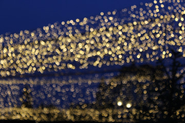 Bokeh lights, gold colors, garland on the street.