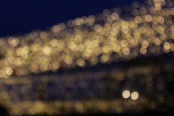 Bokeh lights, gold colors, garland on the street.