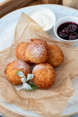 Cottage cheese donut balls with cherry jam and sour cream deep fried