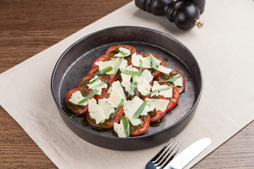 Traditional italian caprese with sliced ripe tomato, basil and parmesan