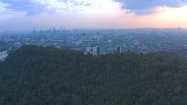 4k Scenic Aerial View of Bukit Tabur Quartz Ridge revealing dramatic sunset of Kuala Lumpur City Skyline. Establishing Shot