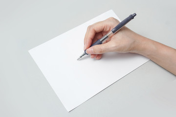 Women hand holding pen writing on white paper a5 background.