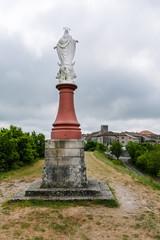 Fototapeta na wymiar Statue of the Virgin Mary from behind overlooking Castelnau-de-Montmiral