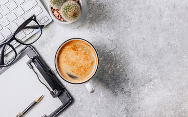 Office desk table with computer, supplies, cup of coffee and cactus in a pot. Work at home during quarantine. Top view with copy space. Flat lay