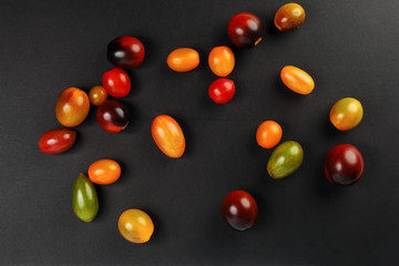 Fresh ripe mixed tomato verity assorted color on black background