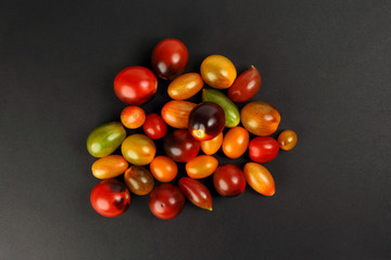 Fresh ripe mixed tomato verity assorted color on black background