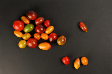 Fototapeta na wymiar Fresh ripe mixed tomato verity assorted color on black background