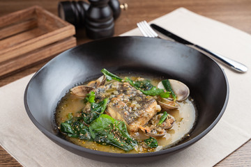 Marinated cod with stewed scallops and spinach, dressed with hazelnut sauce