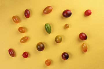 Fresh ripe mixed tomato verity assorted color on yellow background