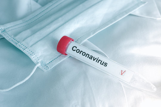 coronavirus test. Test tube lying on inspiratory protective respiratory mask. COVID-19 test or SARS-CoV-2 test. Stop spreading