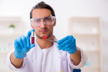 Young male chemist in perfume synthesis concept