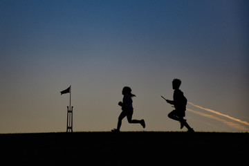 Fototapeta na wymiar Silhouette of children running at sunset in Australia Parliament House
