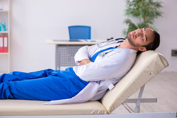Young male doctor being tired after night shift