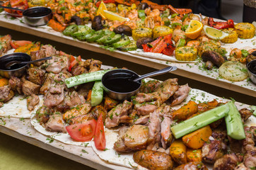 meat with vegetables and potatoes, seafood with soy sauce on a wooden table from boards