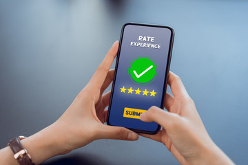 Hand holding smartphone rate your experience on application mobile.
