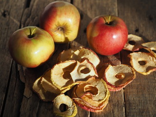 Homemade dried fruit Apple chips with fresh apples on a rustic wooden dark table.The benefits of dried fruit.