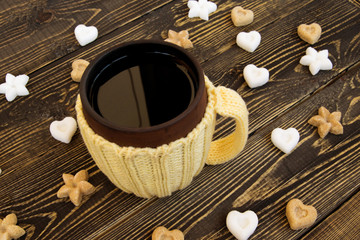 Cup of tea and sugar in form of heart and flower on wooden background