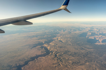 Looking out the window of an airplane soaring high above the cracks and fissures in the landscape below.